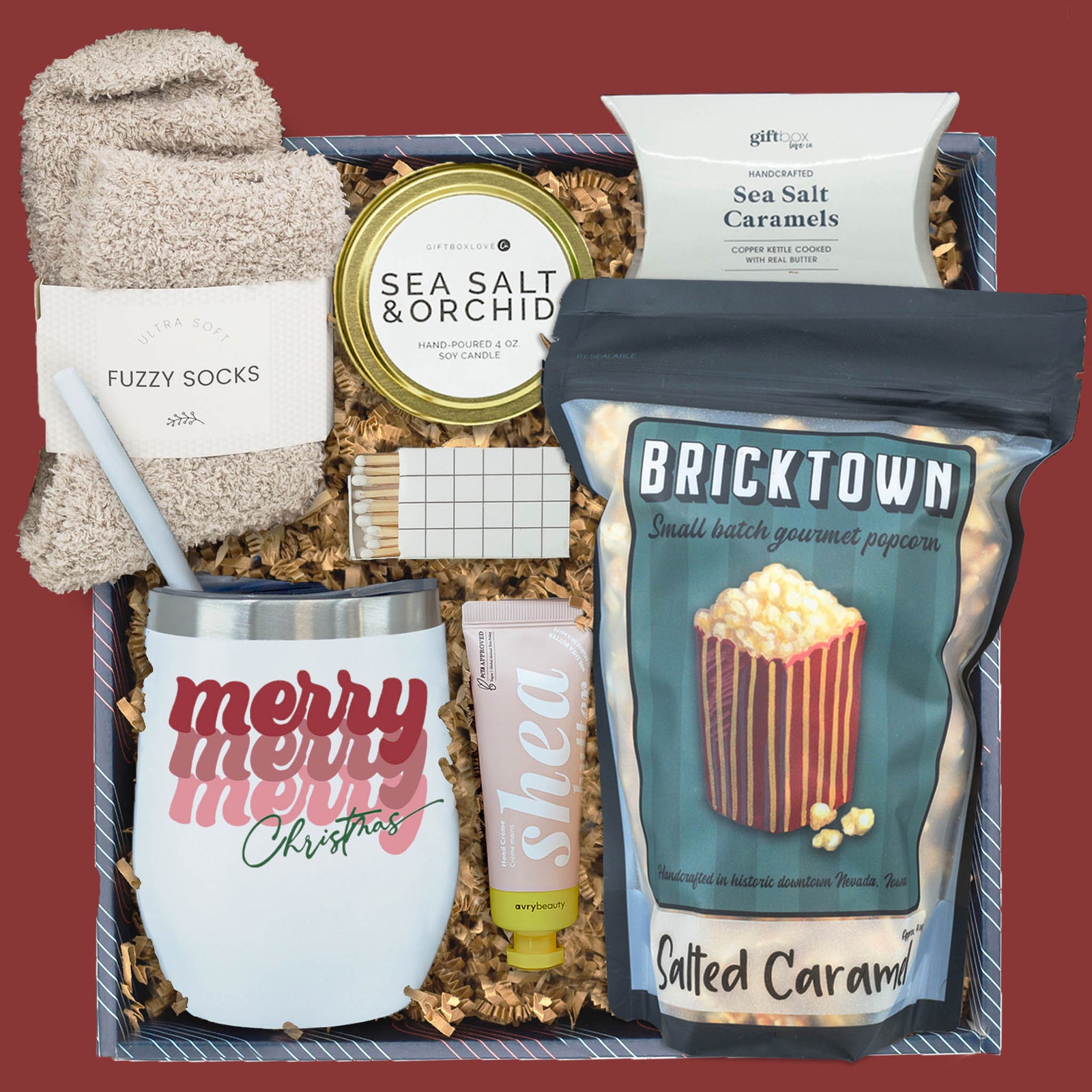 Merry and Cozy Christmas gift box with popcorn, candle, socks, and tumbler
