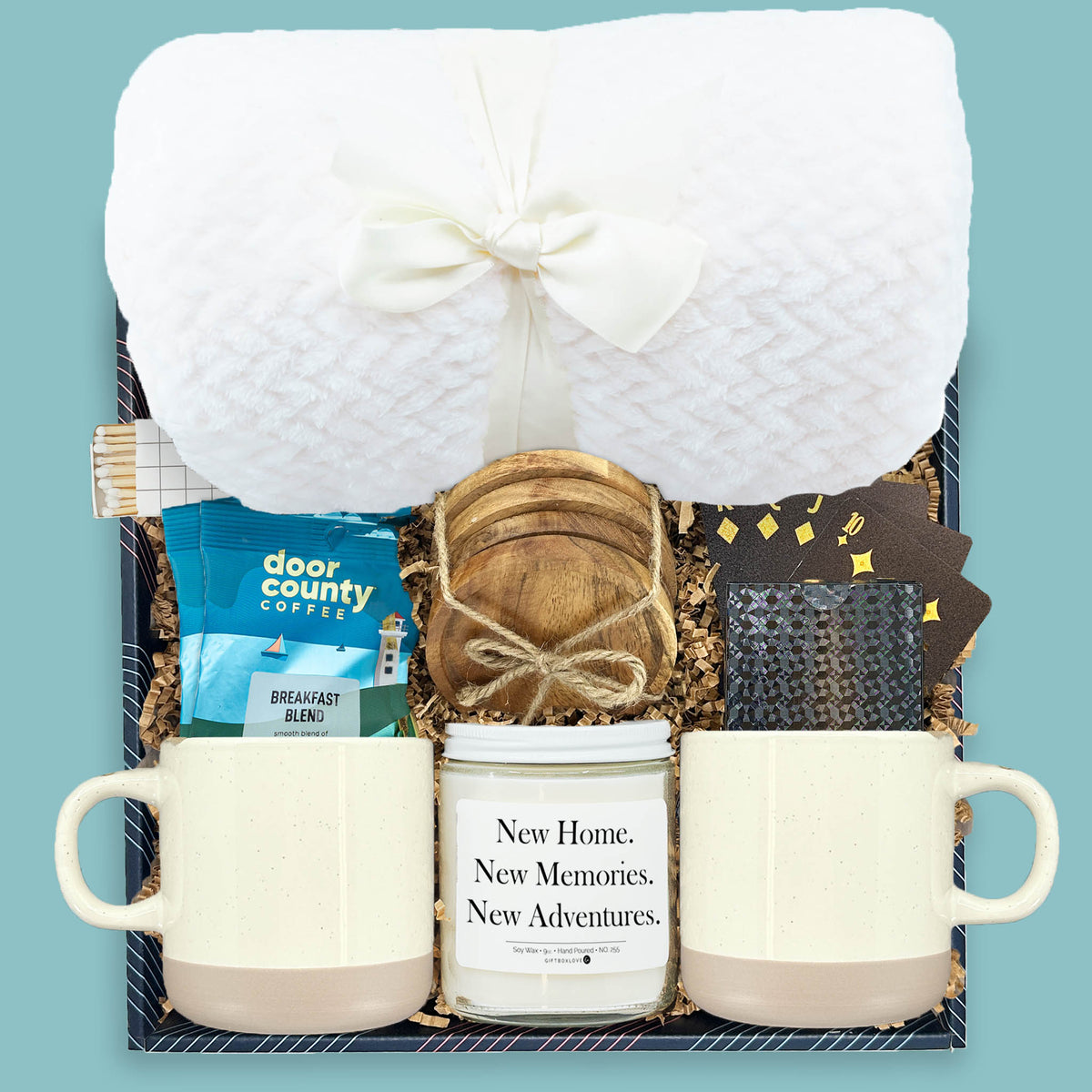 Housewarming gift box with blanket, mugs, coffee, candle, wood coasters, and playing cards
