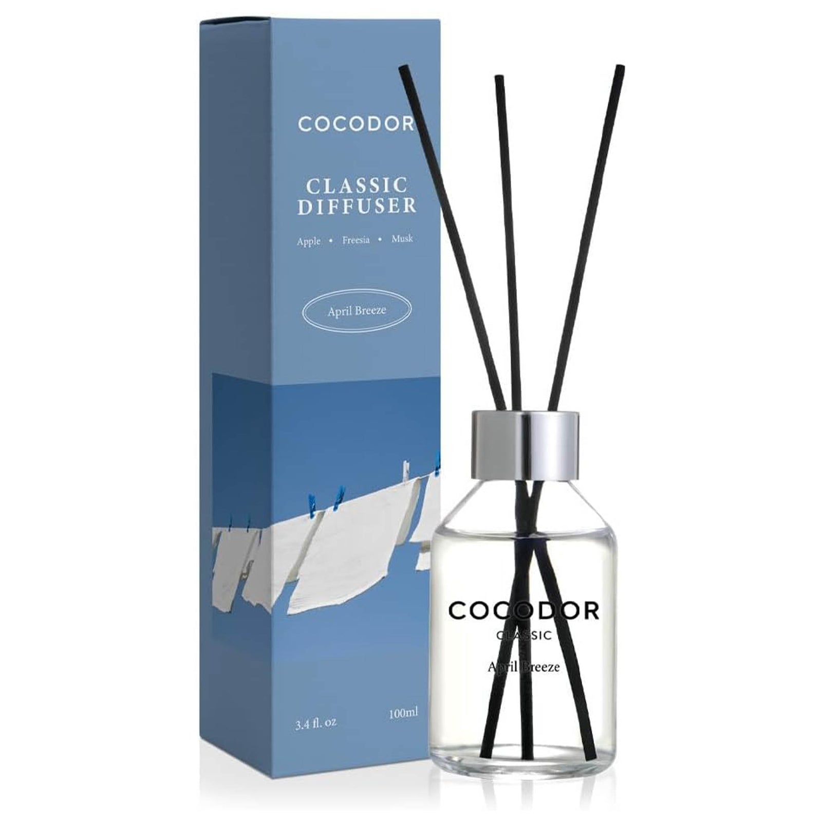 April Breeze 3.4 oz reed diffuser with apple, freesia, and musk fragrance, clear glass bottle, black reeds, and blue packaging