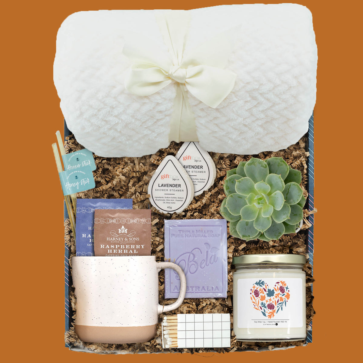 Autumn Afternoon Gift Box with plush blanket, stoneware mug, herbal tea, honey sticks, lavender shower steamers, lavender soap, succulent, autumn soy candle, and decorative matches.