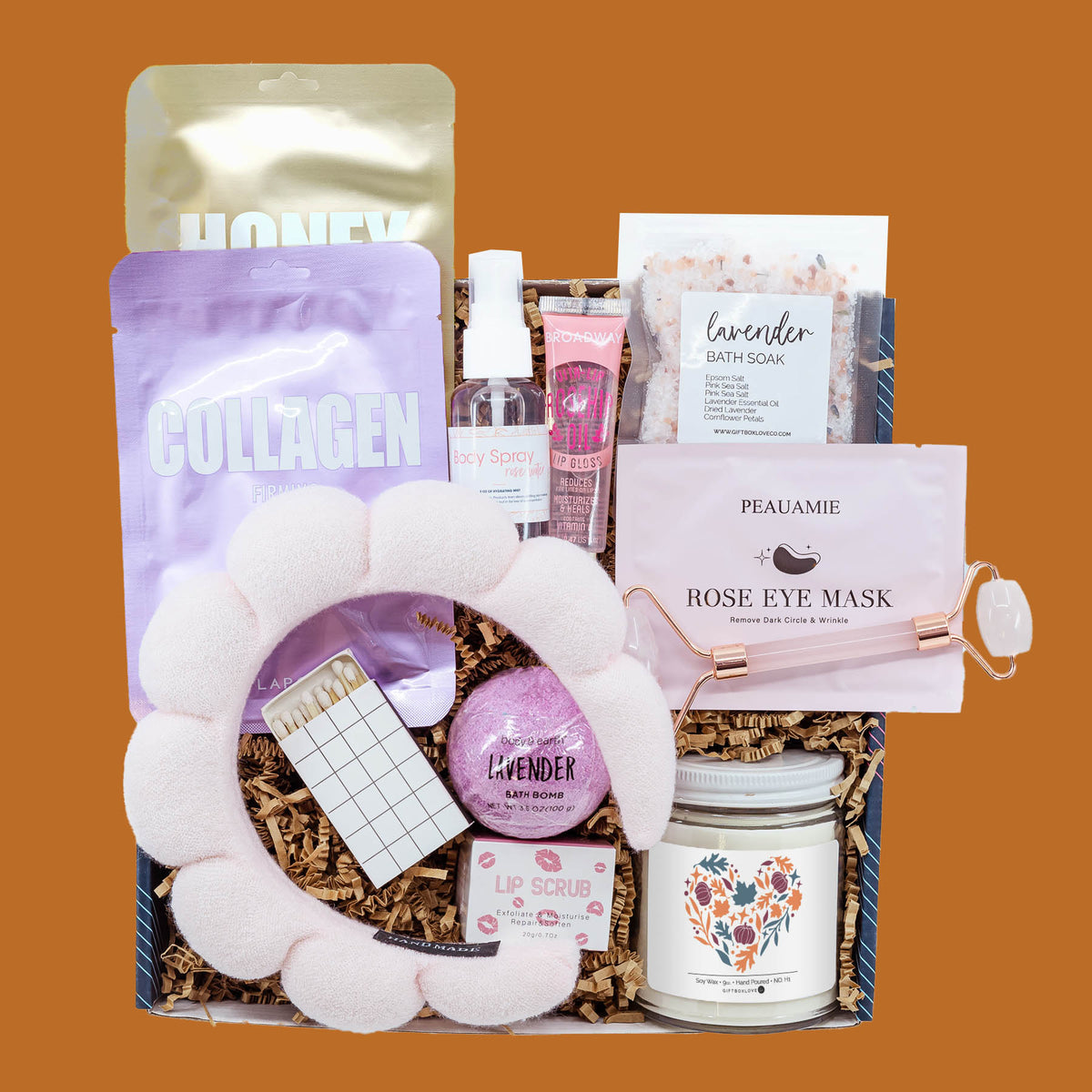 Autumn Escape Gift Box with plush spa headband, facial masks, rose quartz roller, lavender bath soak, bath bomb, body spray, lip care, autumn soy candle, and decorative matches.