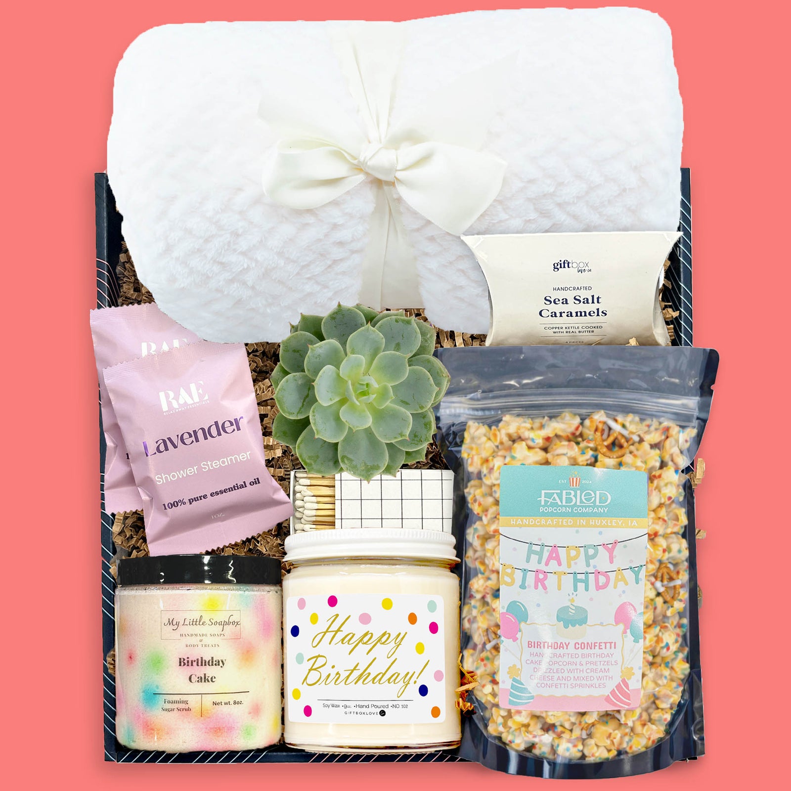 Birthday gift box with white plush blanket, succulent, vanilla candle, birthday cake sugar scrub, lavender shower steamers, caramels, and birthday popcorn.