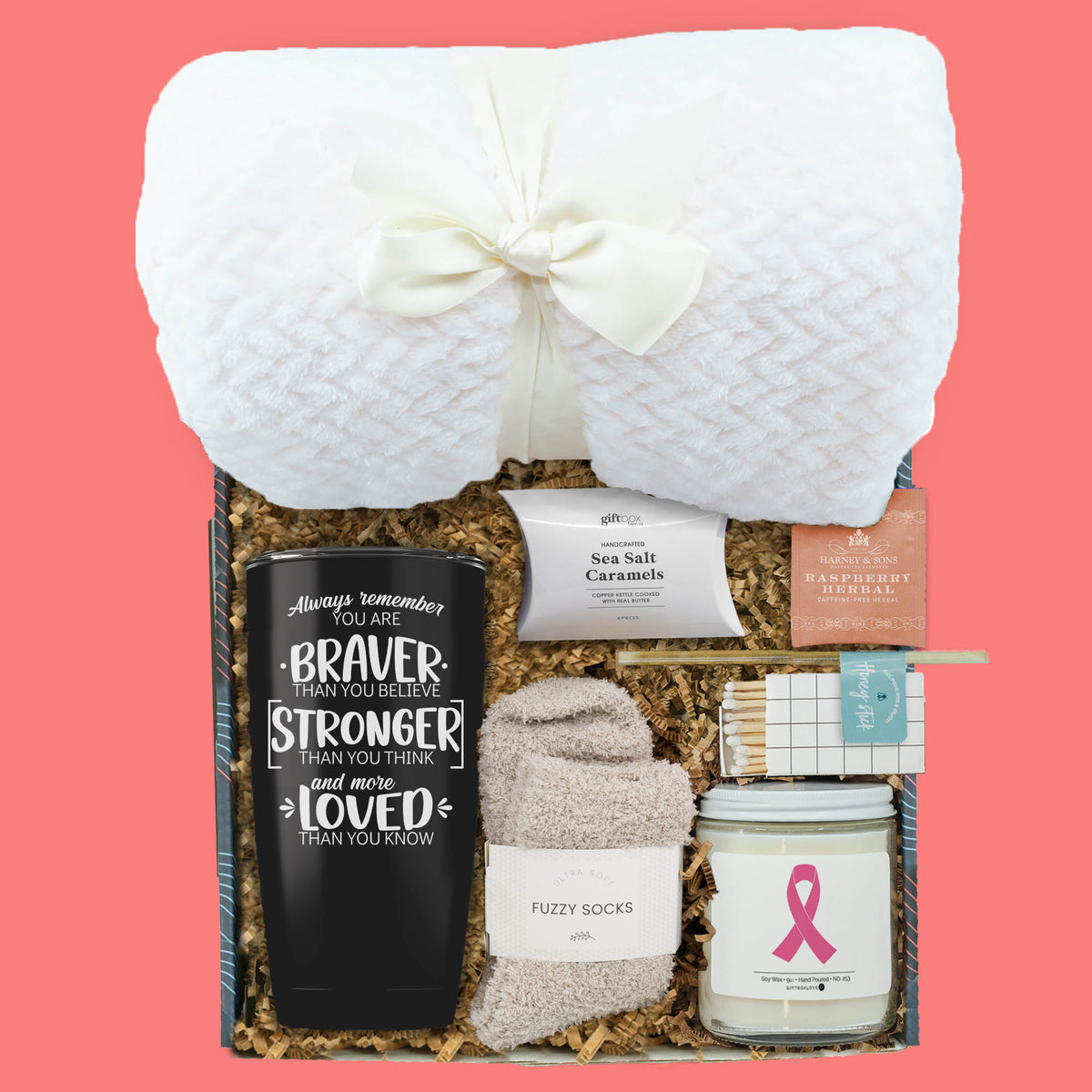 Breast cancer support gift box with tumbler, candle, blanket, socks, and comfort treats.