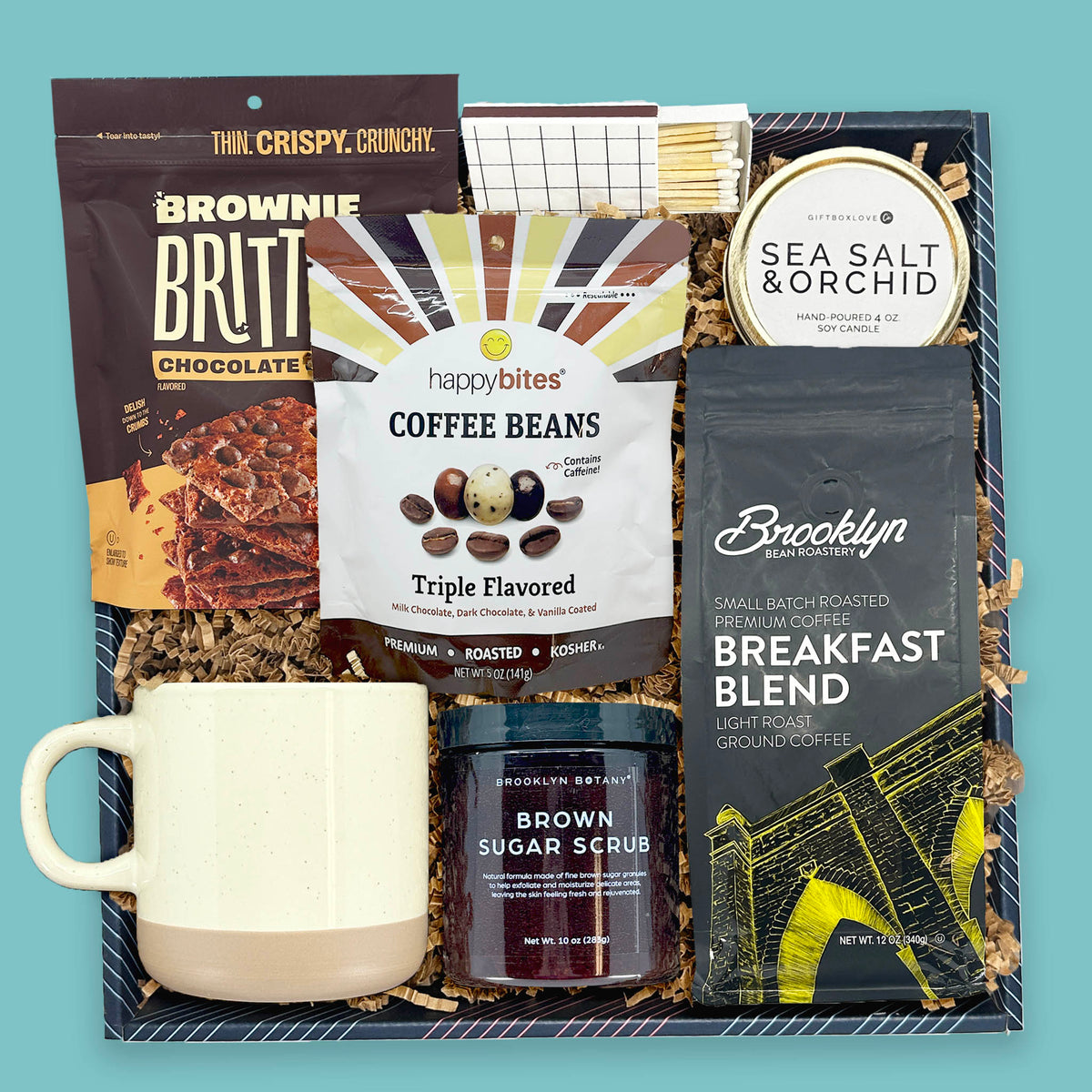 gift box with coffee mug candle brownie brittle coffee beans and sugar scrub