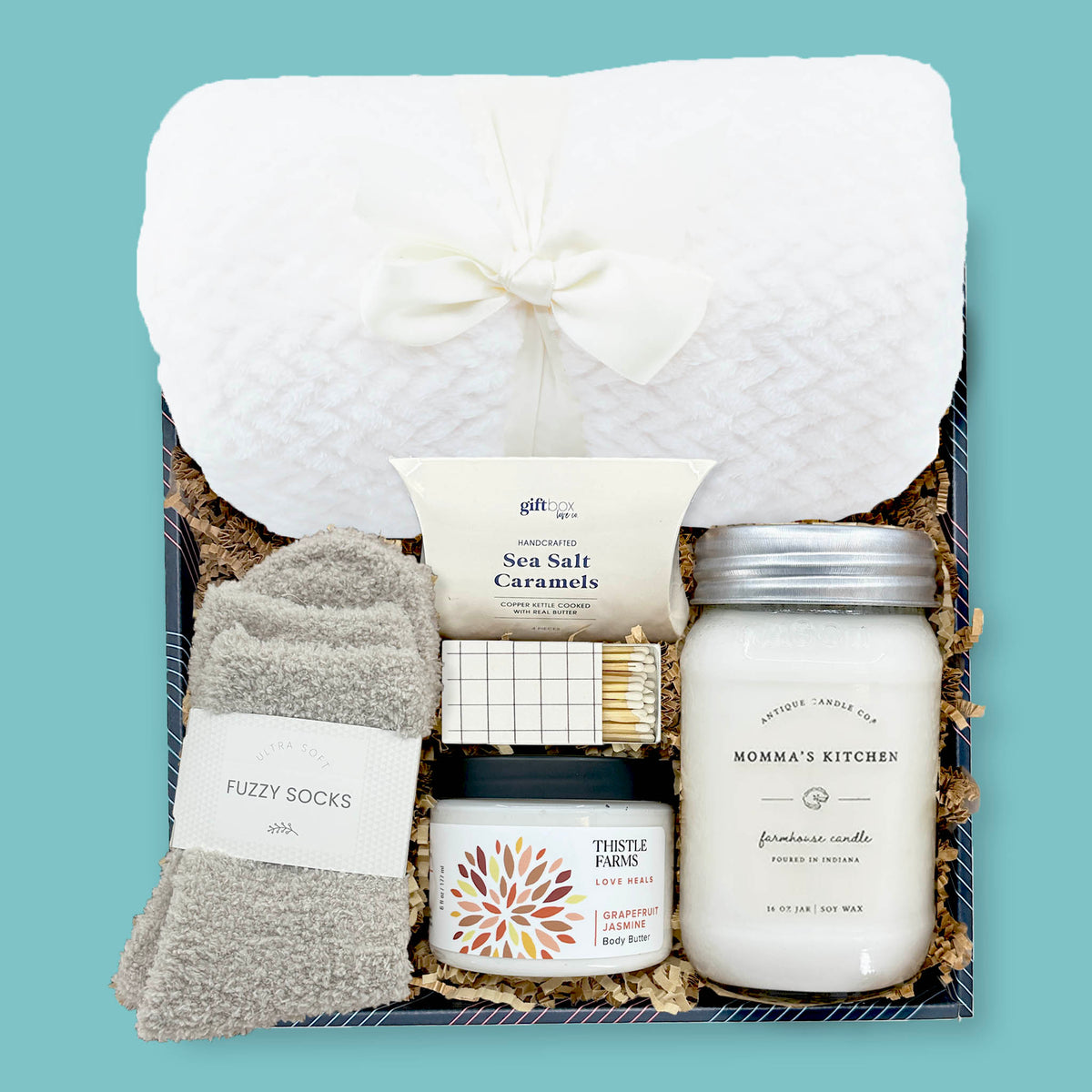 cozy corporate gift box with blanket fuzzy socks candle body butter and caramels