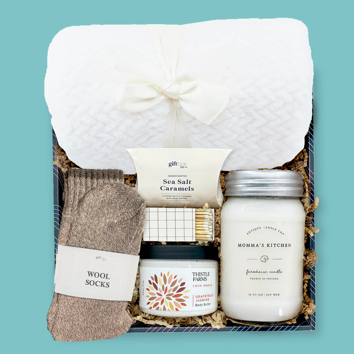 cozy corporate gift box with blanket wool socks candle body butter and caramels