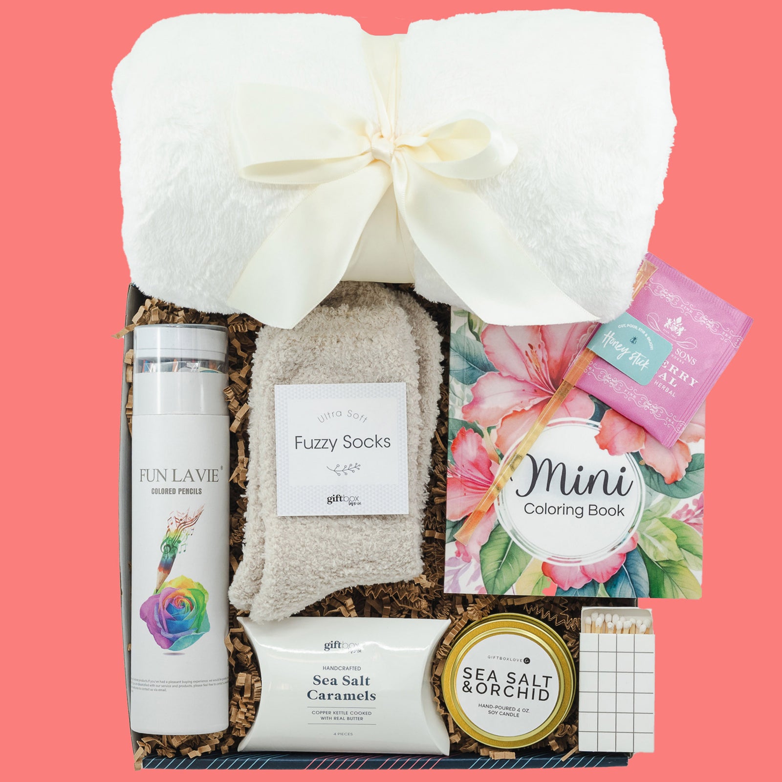 Creative & Cozy Gift Box featuring a soft blanket, coloring book, colored pencils, socks, tea with honey, caramels, a soy candle, and a matchbox—perfect for relaxation.