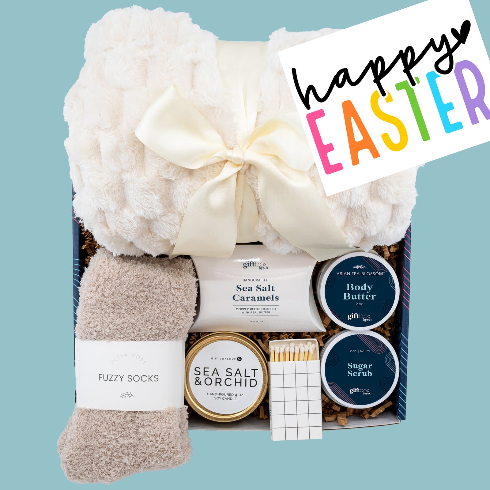 Easter Gift Box for Women featuring a cozy blanket, scented soy candle, fuzzy socks, body butter, sugar scrub, and gourmet caramels—perfect for spring gifting.