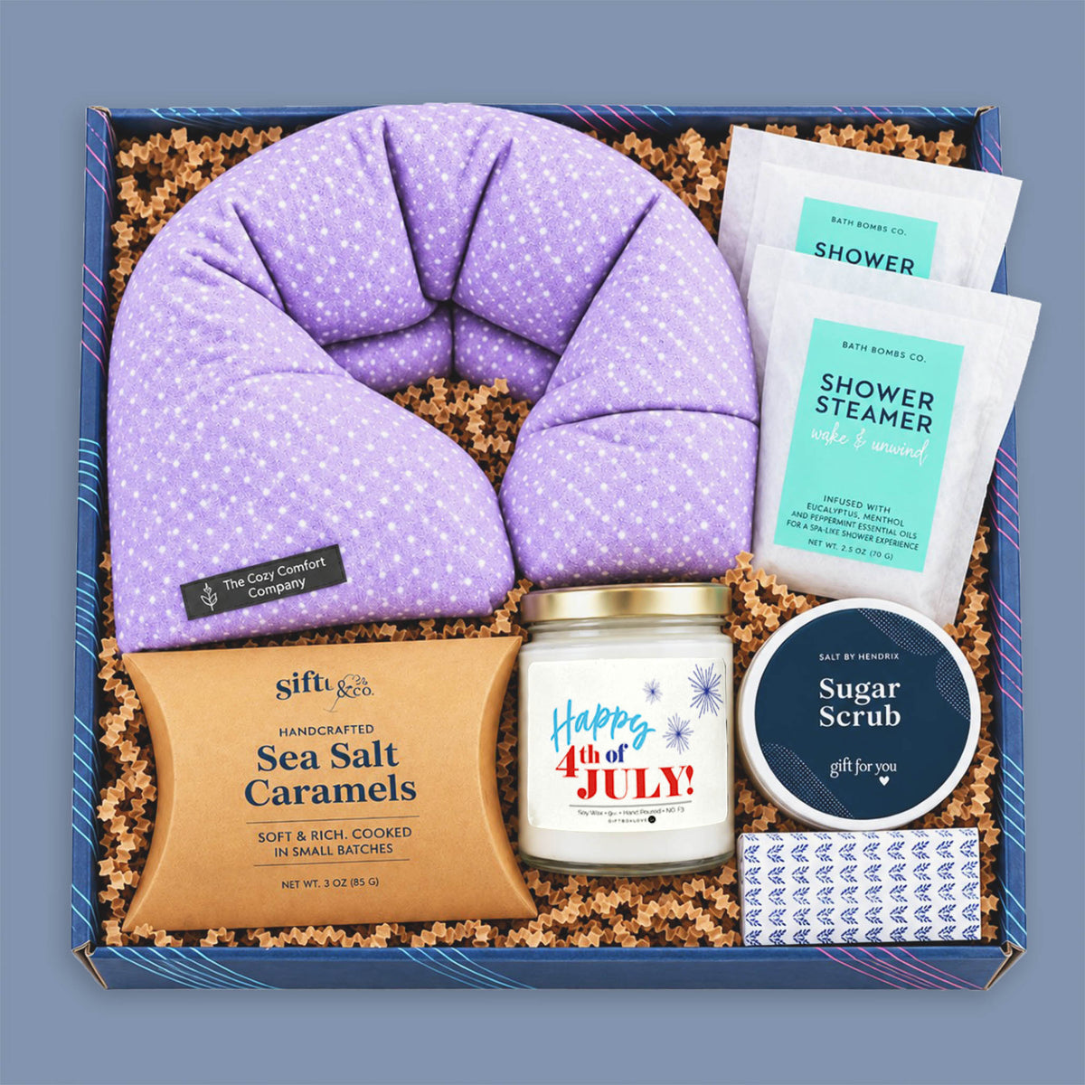 Fourth of July gift box with patriotic candle, lavender neck wrap, shower steamers, sugar scrub, sea salt caramels, and decorative matches