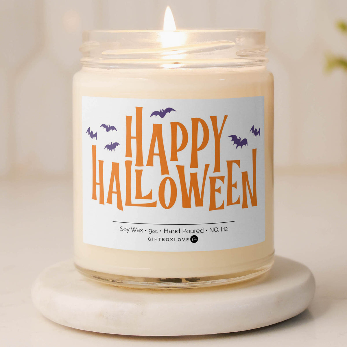 Happy Halloween candle with orange lettering and bats