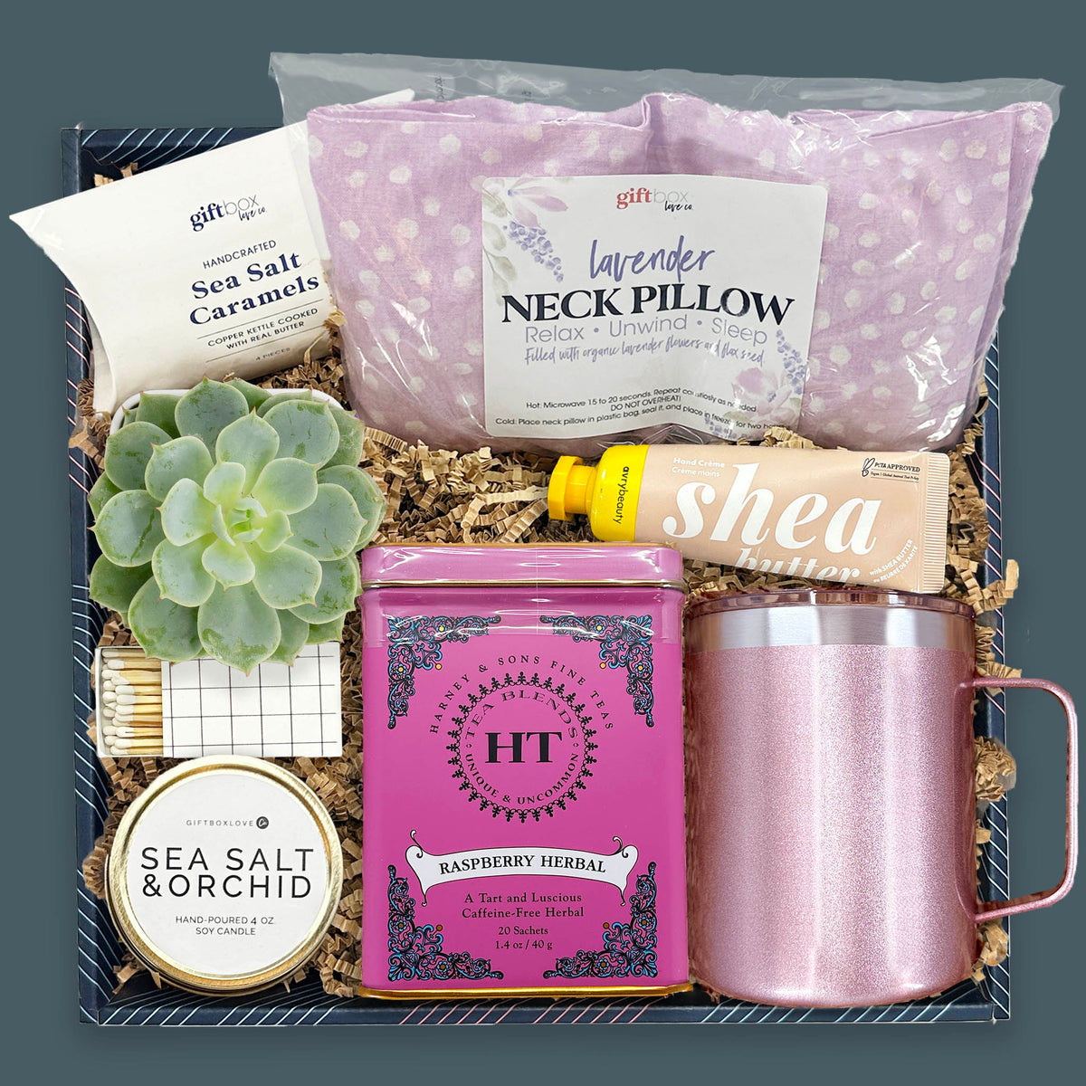 Little Autumn Luxuries Gift Box with lavender neck pillow, herbal tea tin, rose gold camp mug, live succulent, candle, hand cream, and sea salt caramels.