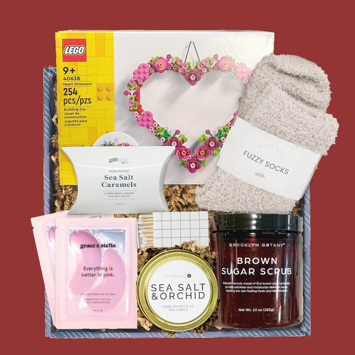 Valentine’s gift box with LEGO heart kit, candle, caramels, fuzzy socks, and self care items