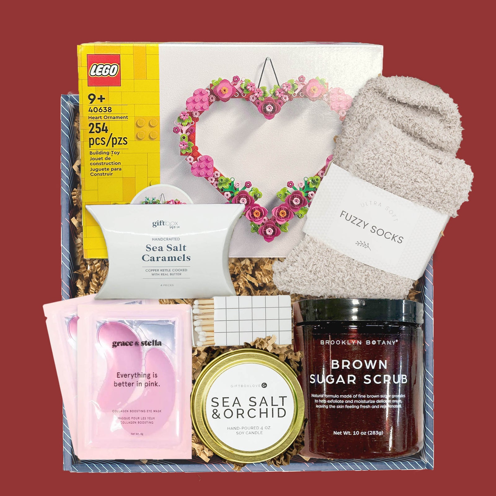 Valentine’s gift box with LEGO heart kit, candle, caramels, fuzzy socks, and self care items