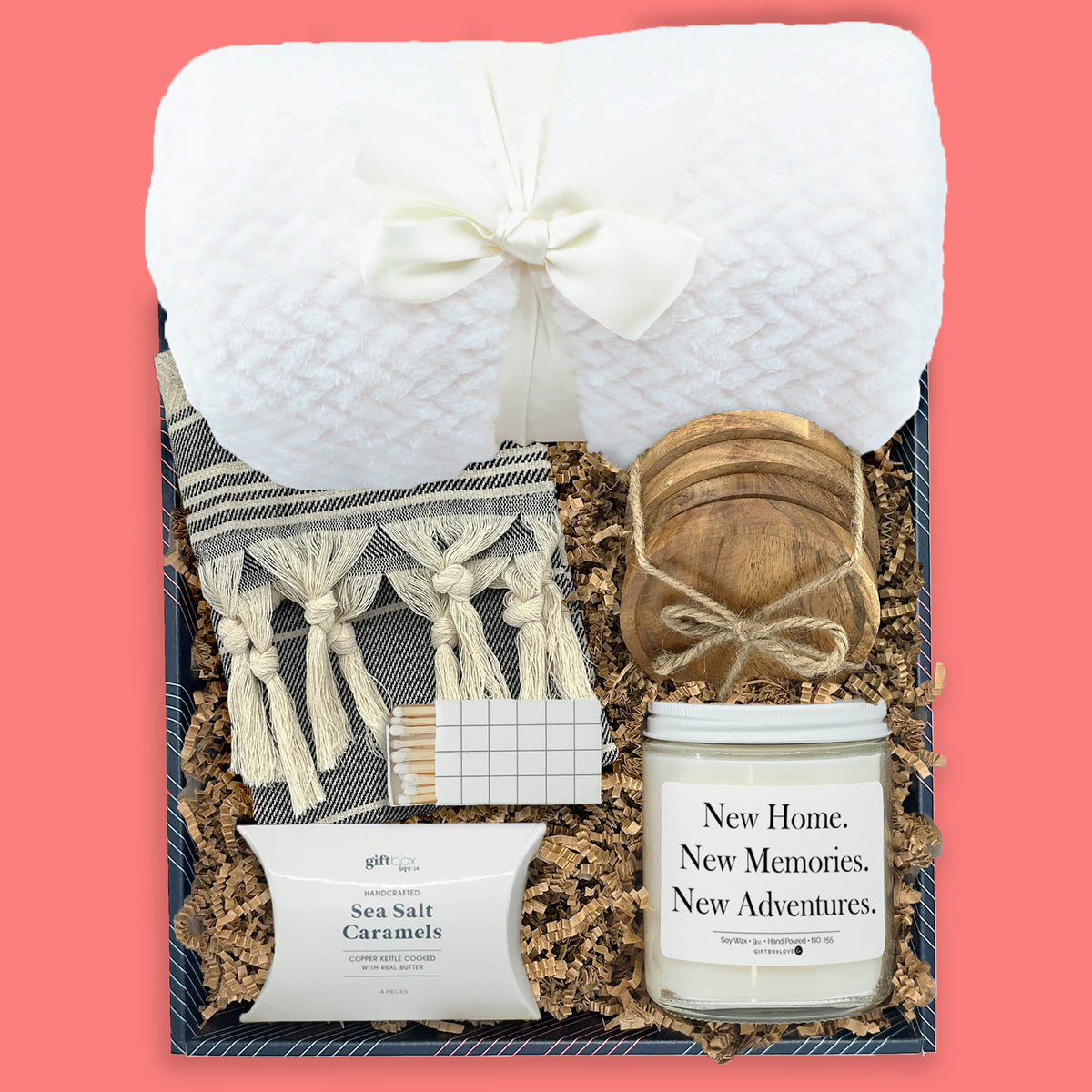 New home gift box with blanket, candle, tea towel, wood coasters, and sea salt caramels