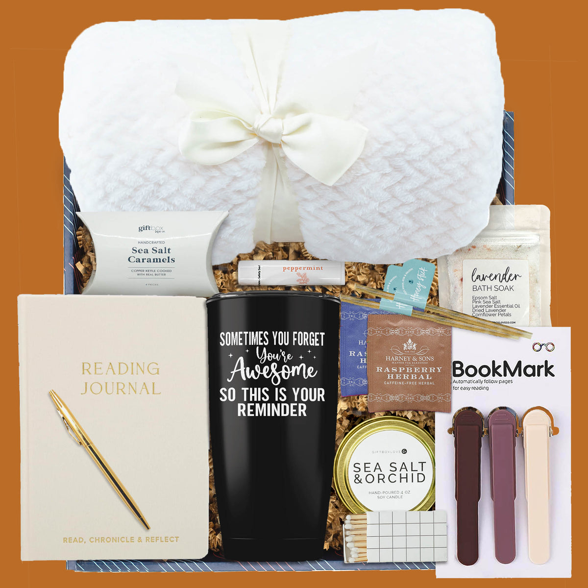 Read Relax & Warm Gift Box with blanket, reading journal, tumbler, tea, candle, bath soak, magnetic bookmarks, and caramels.