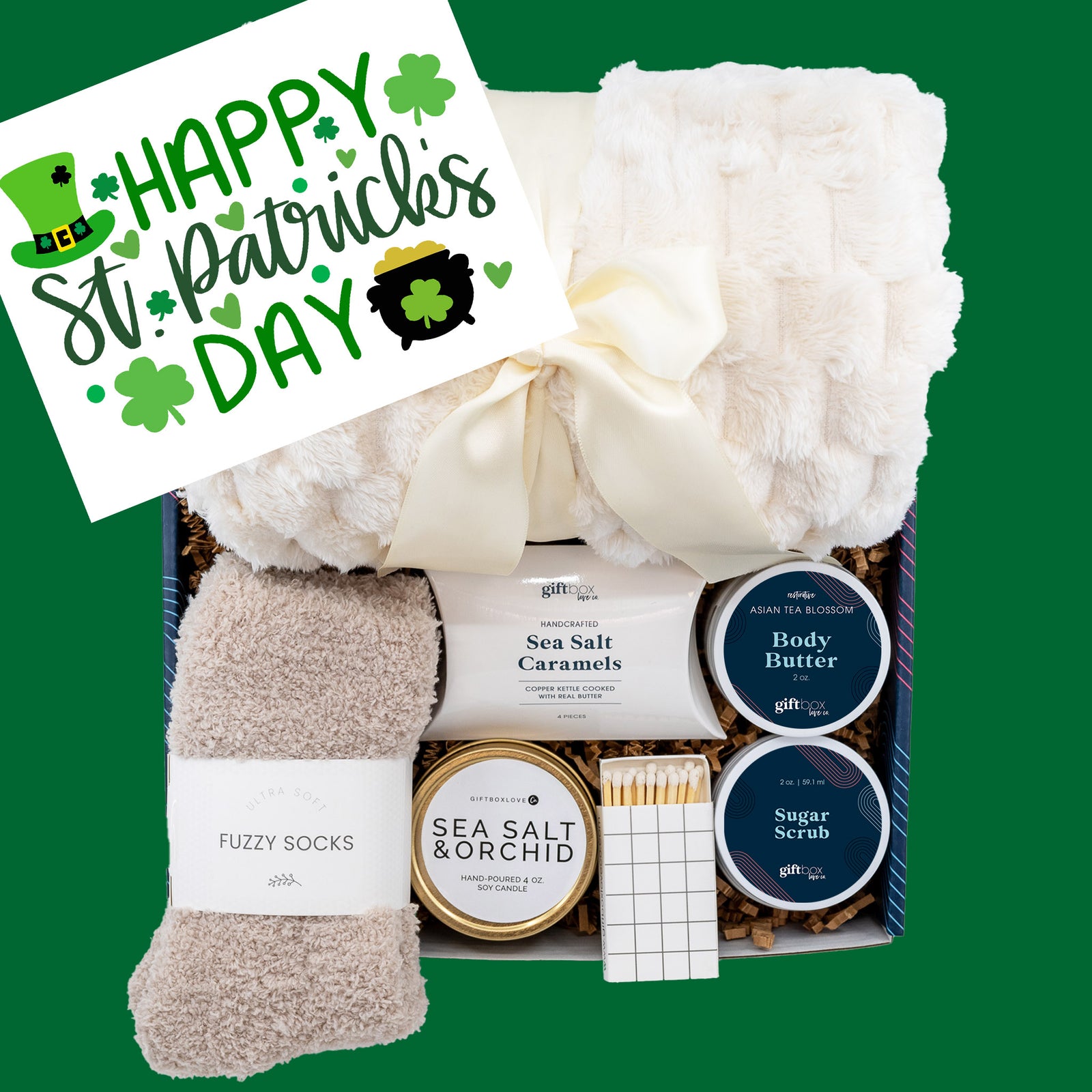 St. Patrick’s Day gift box featuring a cozy blanket, fuzzy socks, scented candle, body butter, sugar scrub, and gourmet caramels for a festive treat.