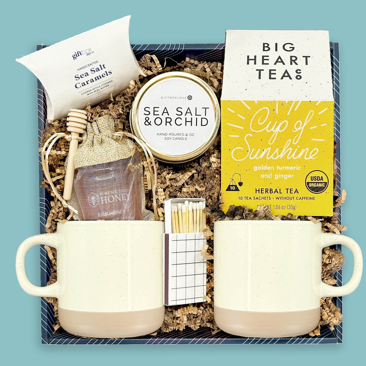 Tea gift box with two mugs, herbal tea, honey, candle, and sea salt caramels