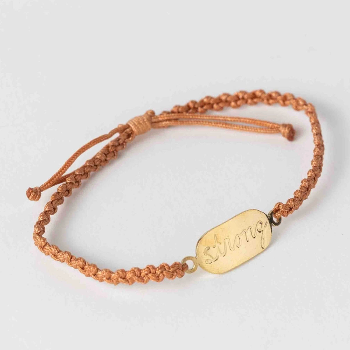 Adjustable braided cord bracelet with gold engraved strong charm
