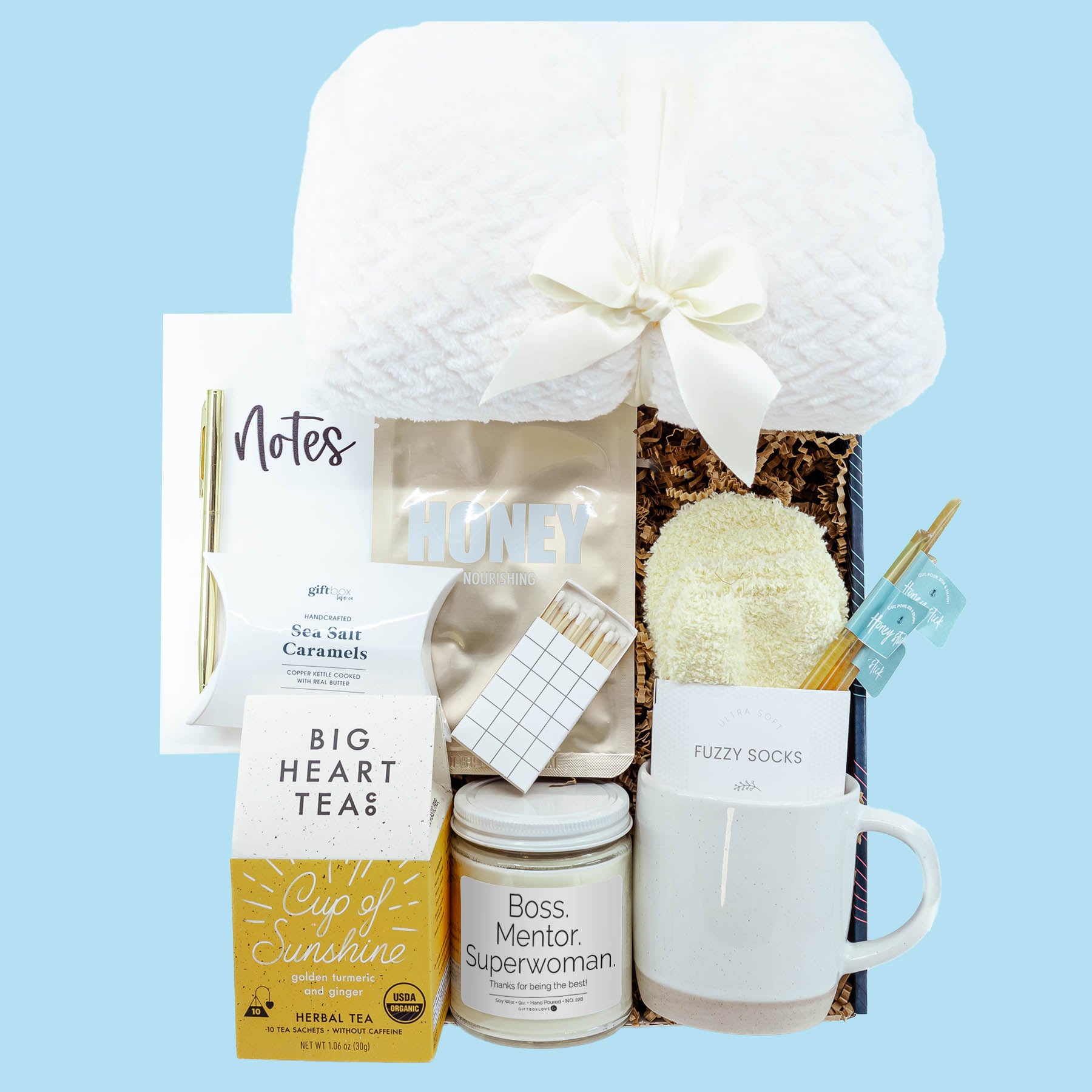 Superwoman Boss Gift Box with blanket, candle, tea, mug, socks, notebook, caramels, and face mask.