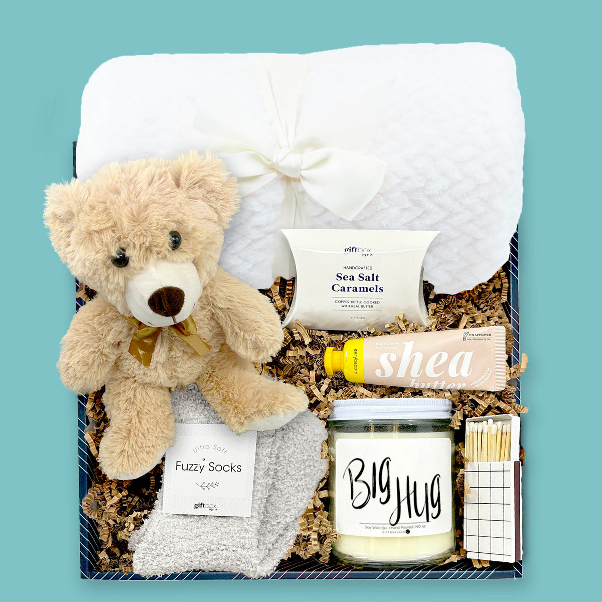 Teddy bear comfort gift box with blanket, fuzzy socks, candle, caramels, and hand cream