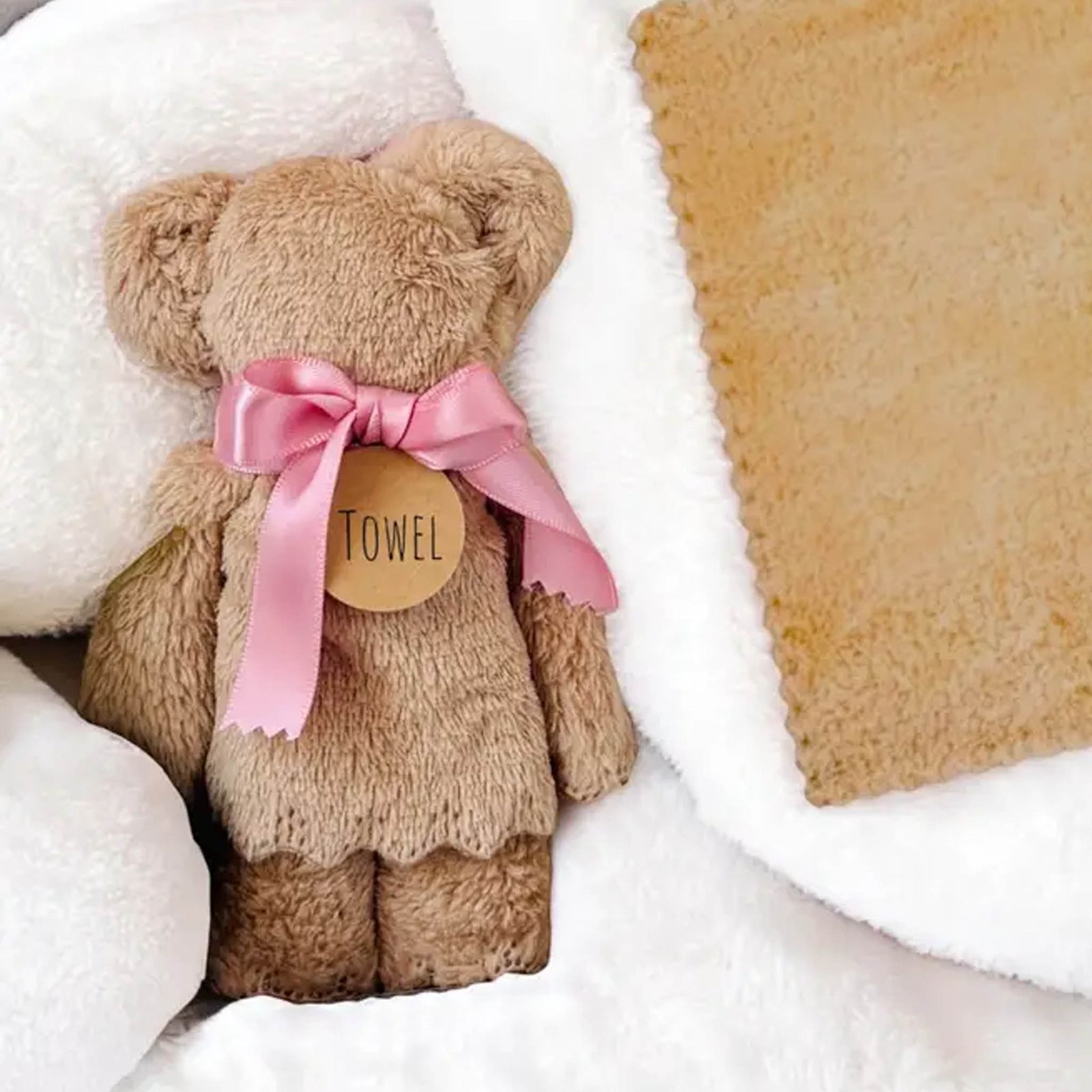 Teddy bear shaped towel tied with ribbon