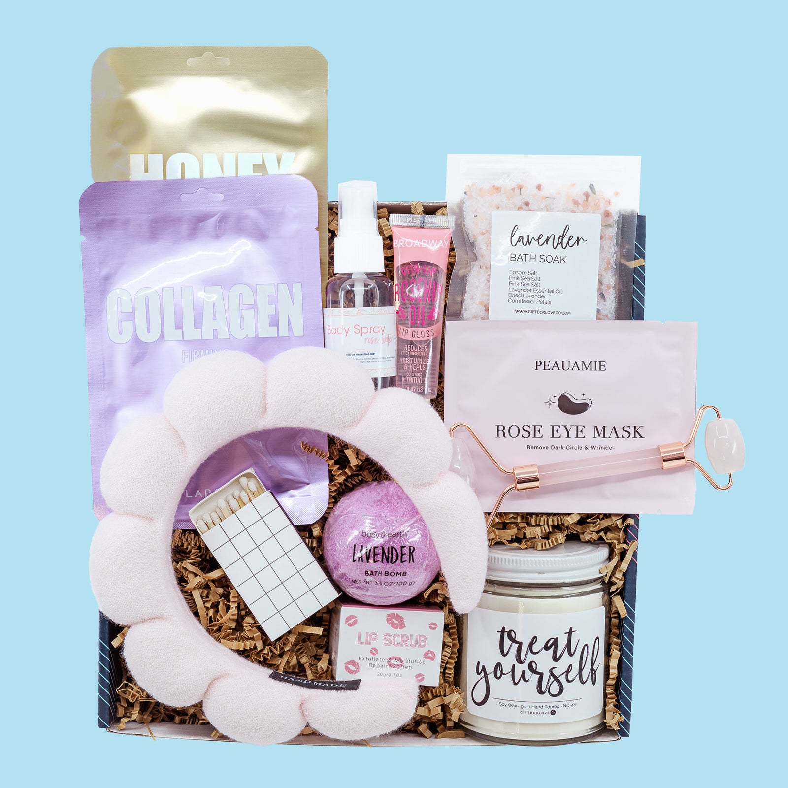 Treat Yourself Gift Box featuring a 9 oz soy candle, lip scrub, bath bomb, spa headband, face masks, lavender bath salt, rose eye mask, and jade facial roller.