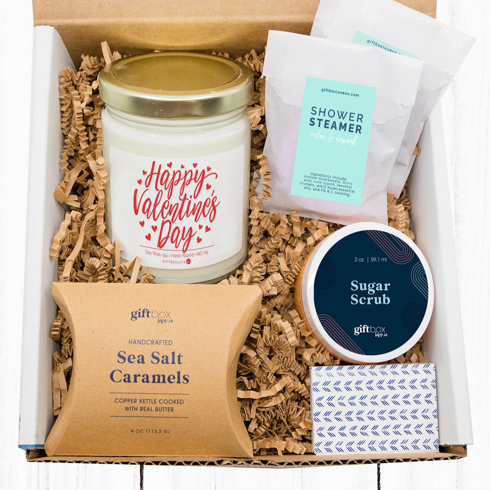 Valentine’s Day Gift Box to Send Loved One featuring a soy candle, matches, caramels, shower steamers, and sugar scrub, perfect for pampering and relaxation.