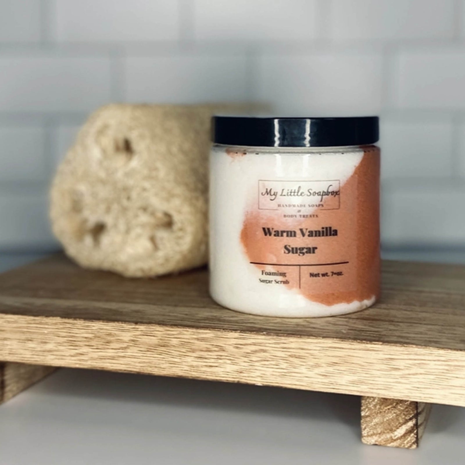 Warm vanilla foaming sugar scrub in jar with exfoliating body polish texture