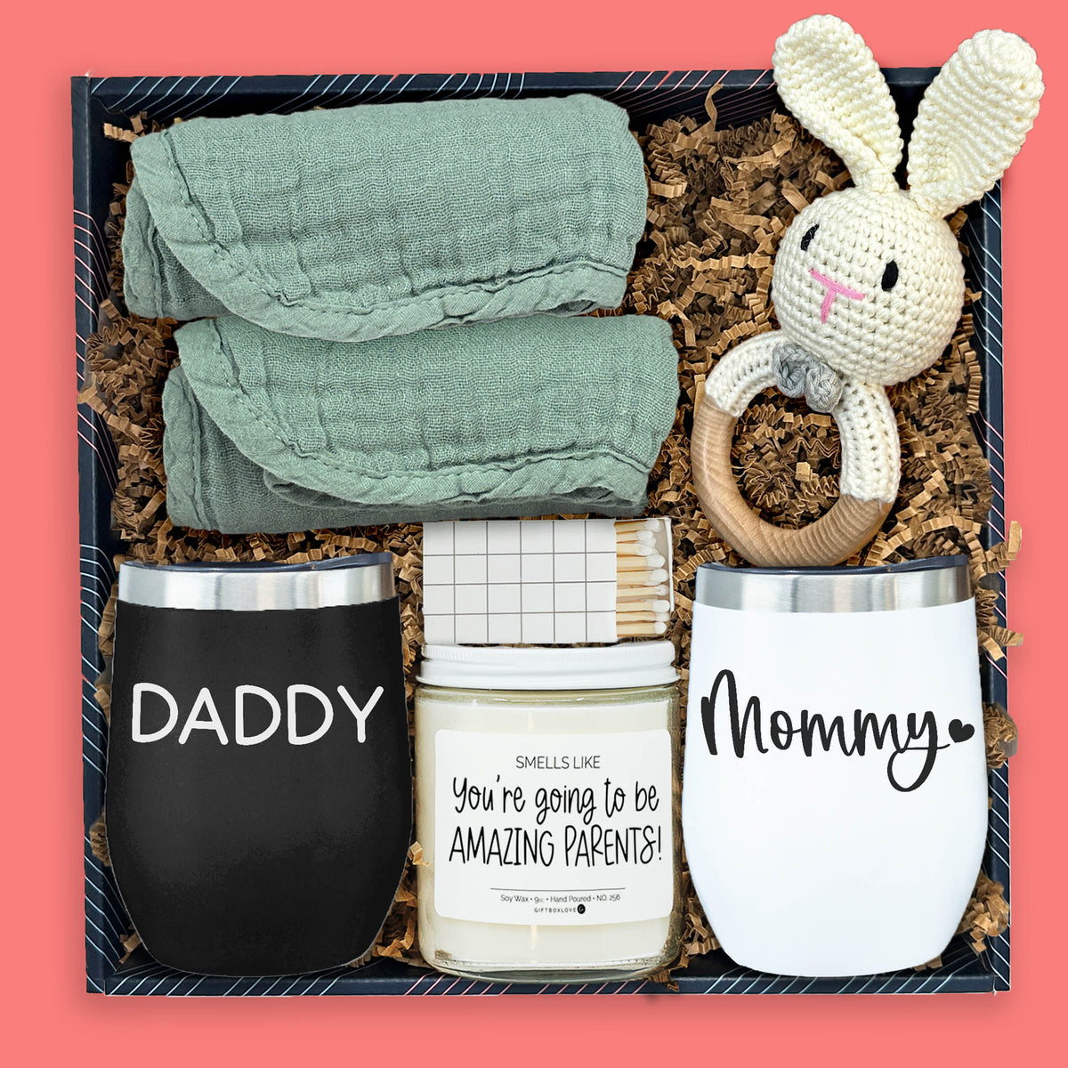 Gift box for new parents with mommy and daddy tumblers, baby rattle, burp cloths, and candle